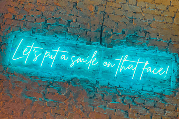 Leuchtschrift mit Text "Let´s put a smile on that face!"